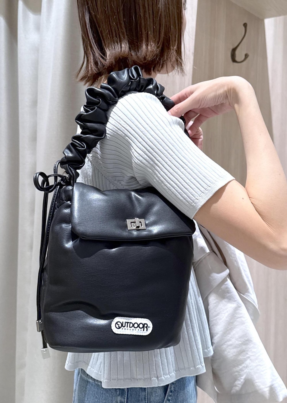 ブルー系のデニムパンツ、ホワイト系のパンプス、ブラック系のショルダーバッグを着用したレディースの春コーディネートの10枚目の写真