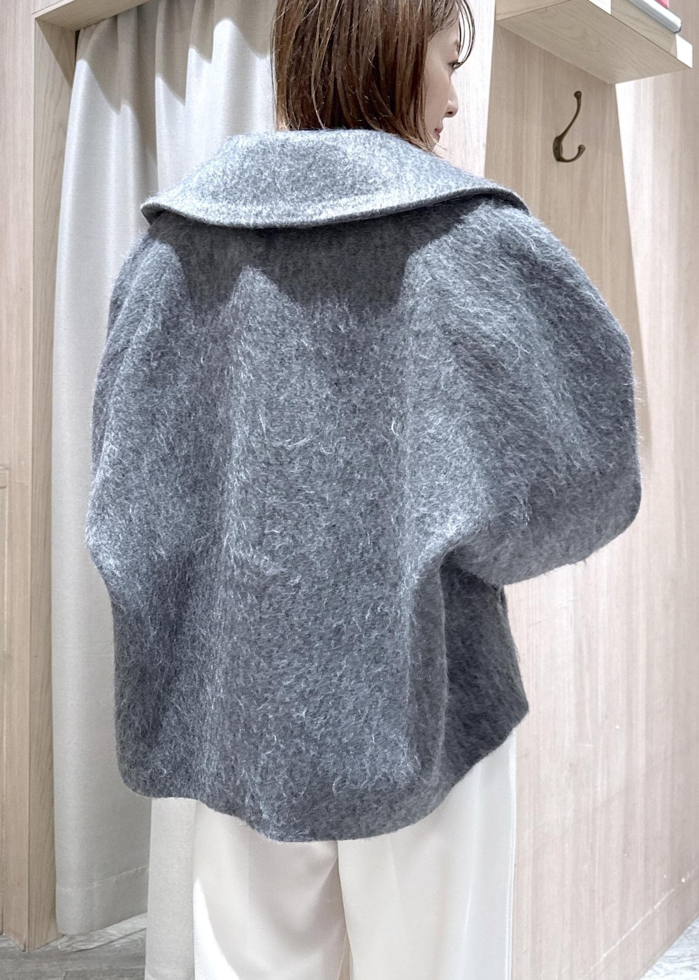 ブラック系のニット/セーター、グレー系のブルゾン、ブラック系のハンドバッグを着用したレディースの冬コーディネートの10枚目の写真