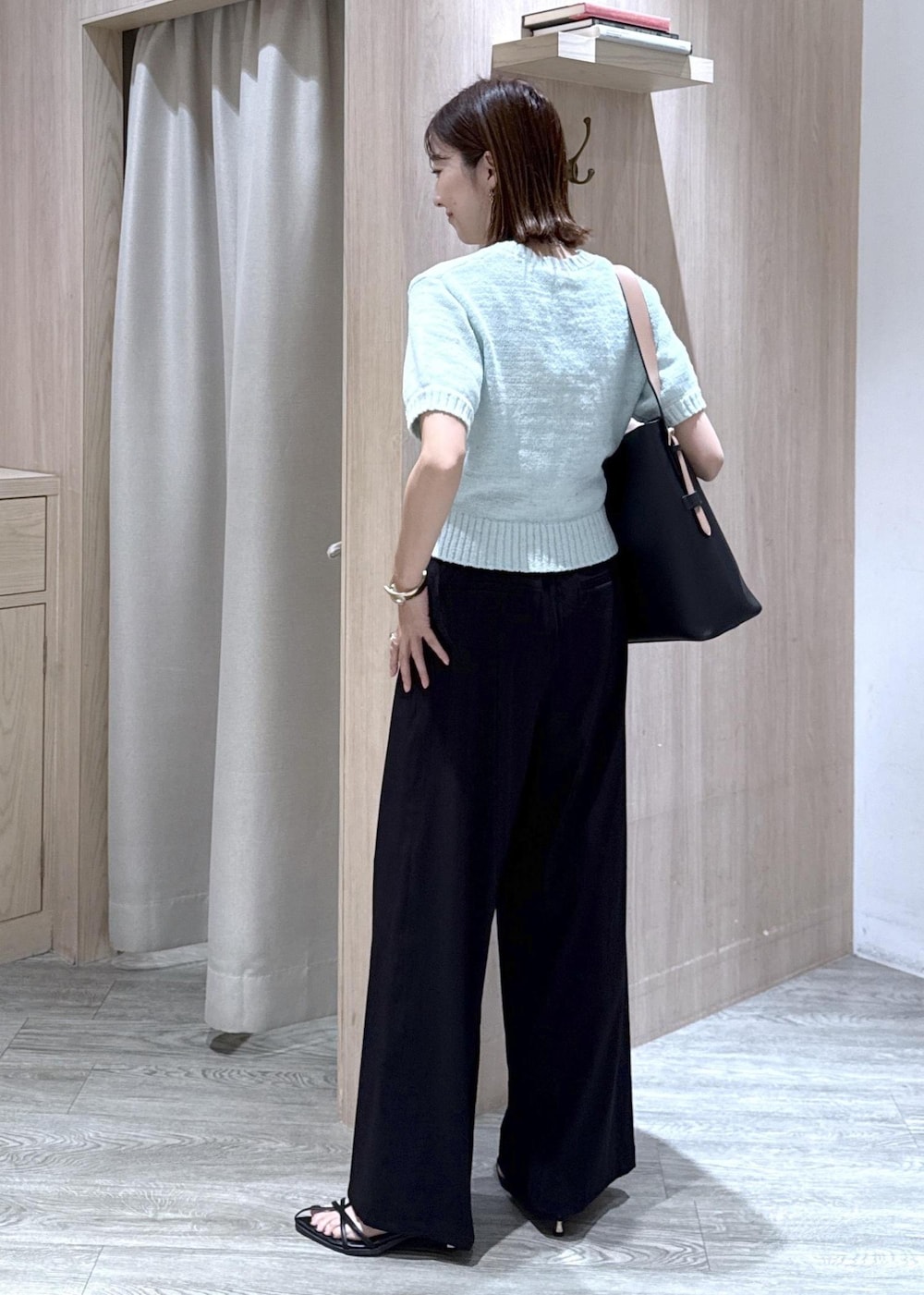ブラック系のトートバッグ、ブラック系のその他パンツ、グリーン系のニット/セーターを着用したレディースの夏コーディネートの2枚目の写真