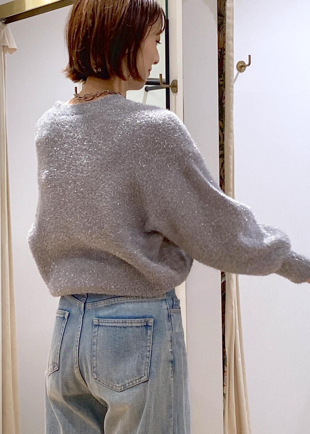 ブラック系のパンプス、グレー系のニット/セーター、ブルー系のデニムパンツを着用したレディースの冬コーディネートの10枚目の写真