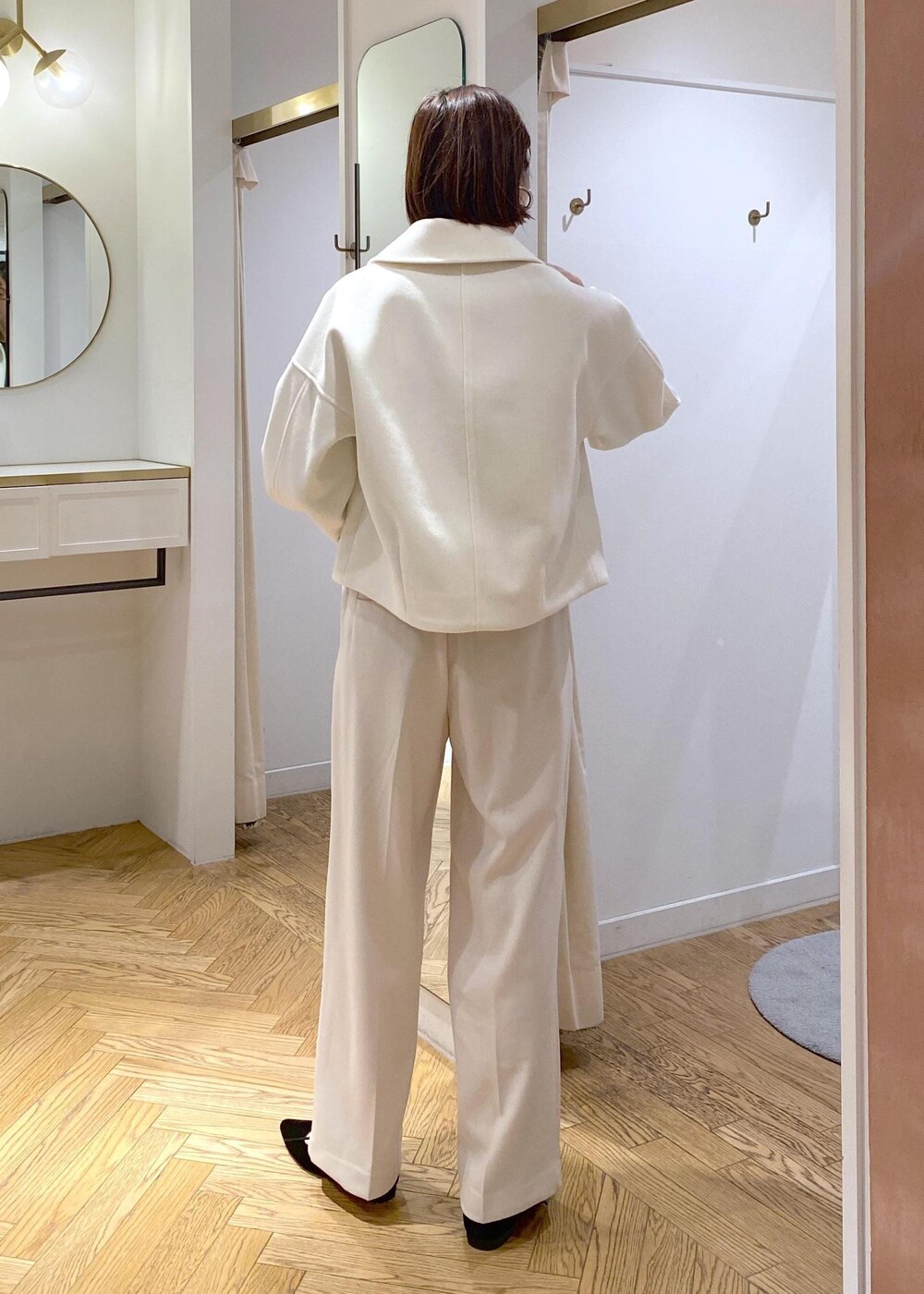 ブルー系のハンドバッグ、ホワイト系のブルゾン、ブラック系のパンプスを着用したレディースの冬コーディネートの4枚目の写真