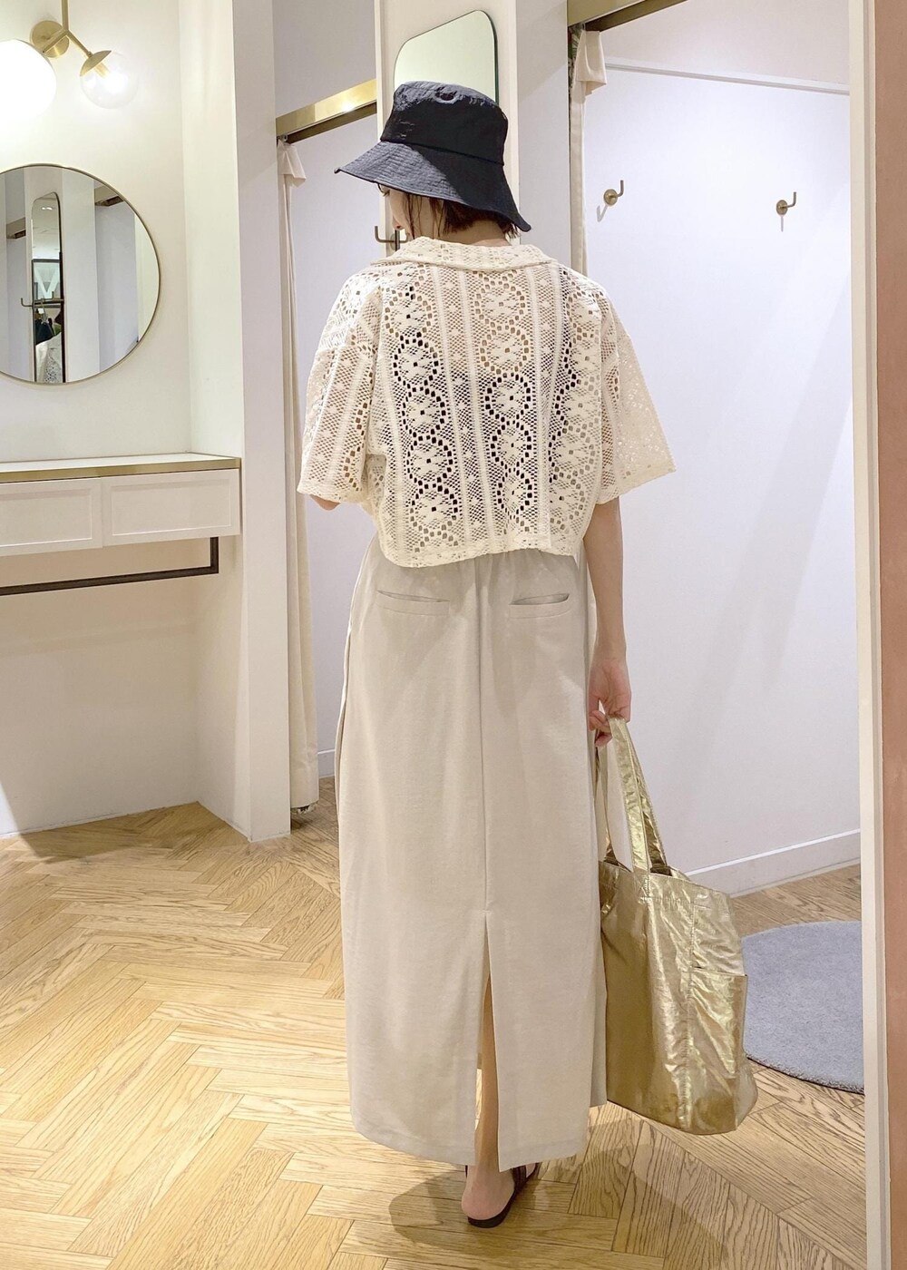 ブラック系のキャミソール、ブラック系のサンダル、ゴールド系のトートバッグを着用したレディースの春コーディネートの3枚目の写真