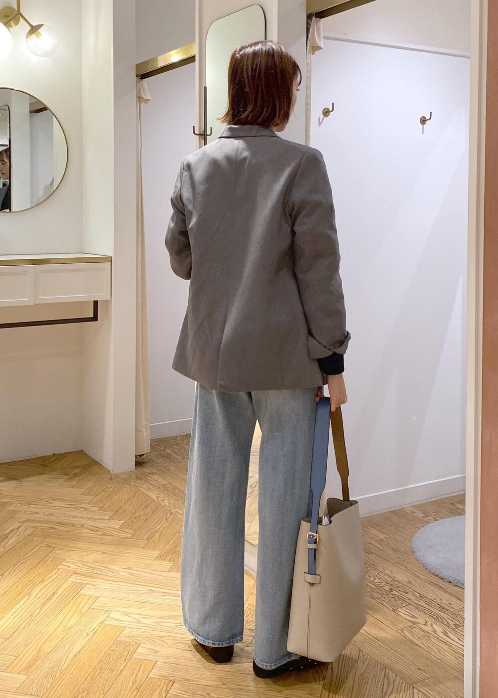 ベージュ系のショルダーバッグ、ブラック系のバレエシューズ、グレー系のテーラードジャケットを着用したレディースの秋コーディネートの2枚目の写真