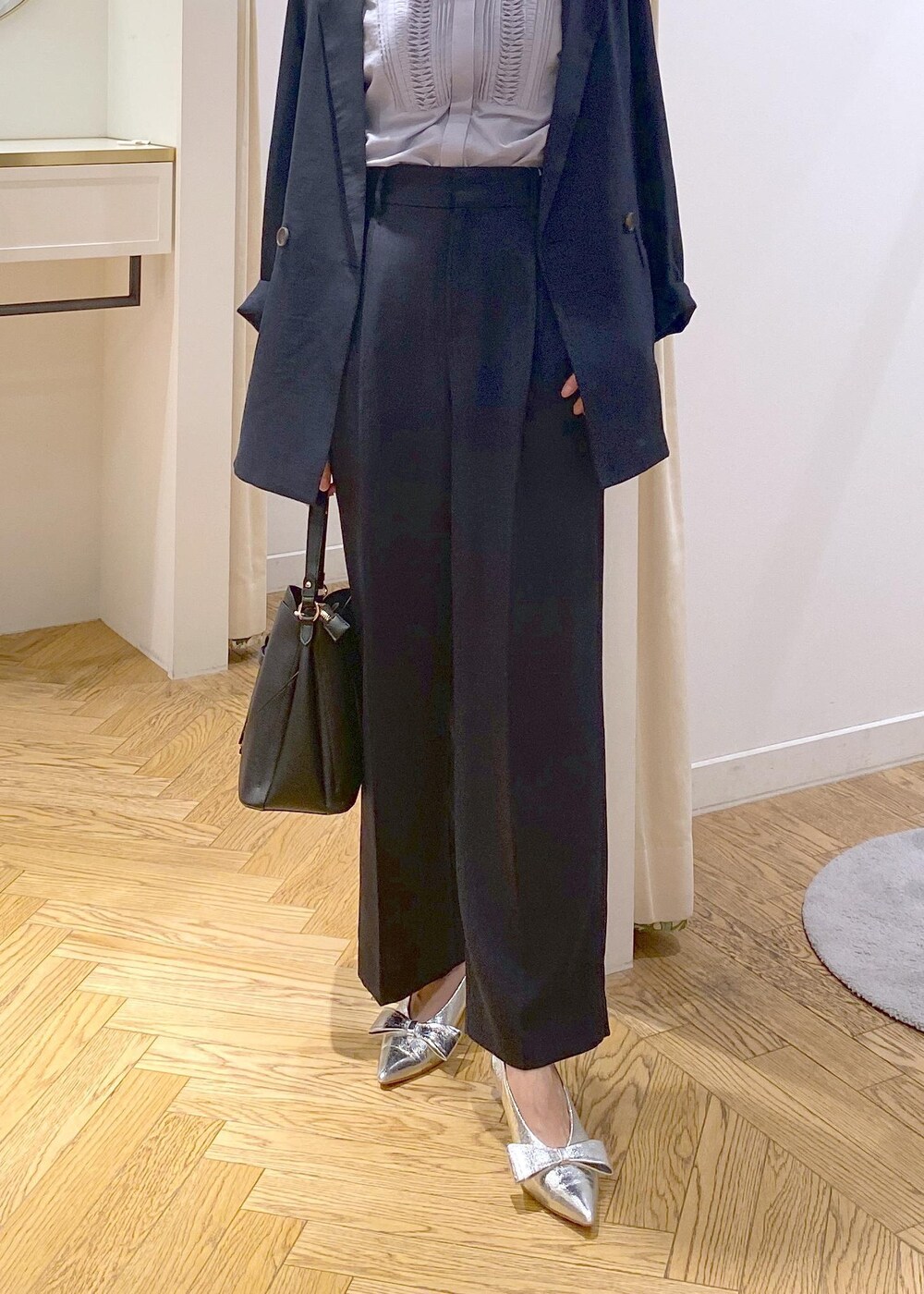 シルバー系のパンプス、ブルー系のスラックス、ブルー系のテーラードジャケットを着用したレディースの夏コーディネートの5枚目の写真