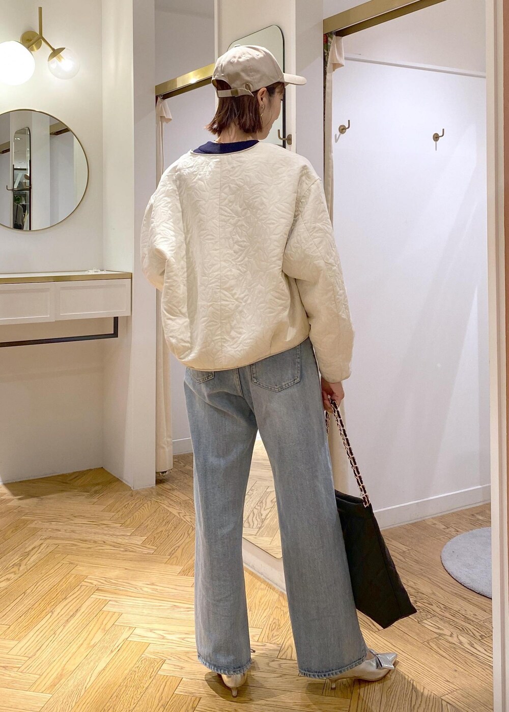 シルバー系のパンプス、ホワイト系のブルゾン、ブルー系のニット/セーターを着用したレディースの秋コーディネートの3枚目の写真