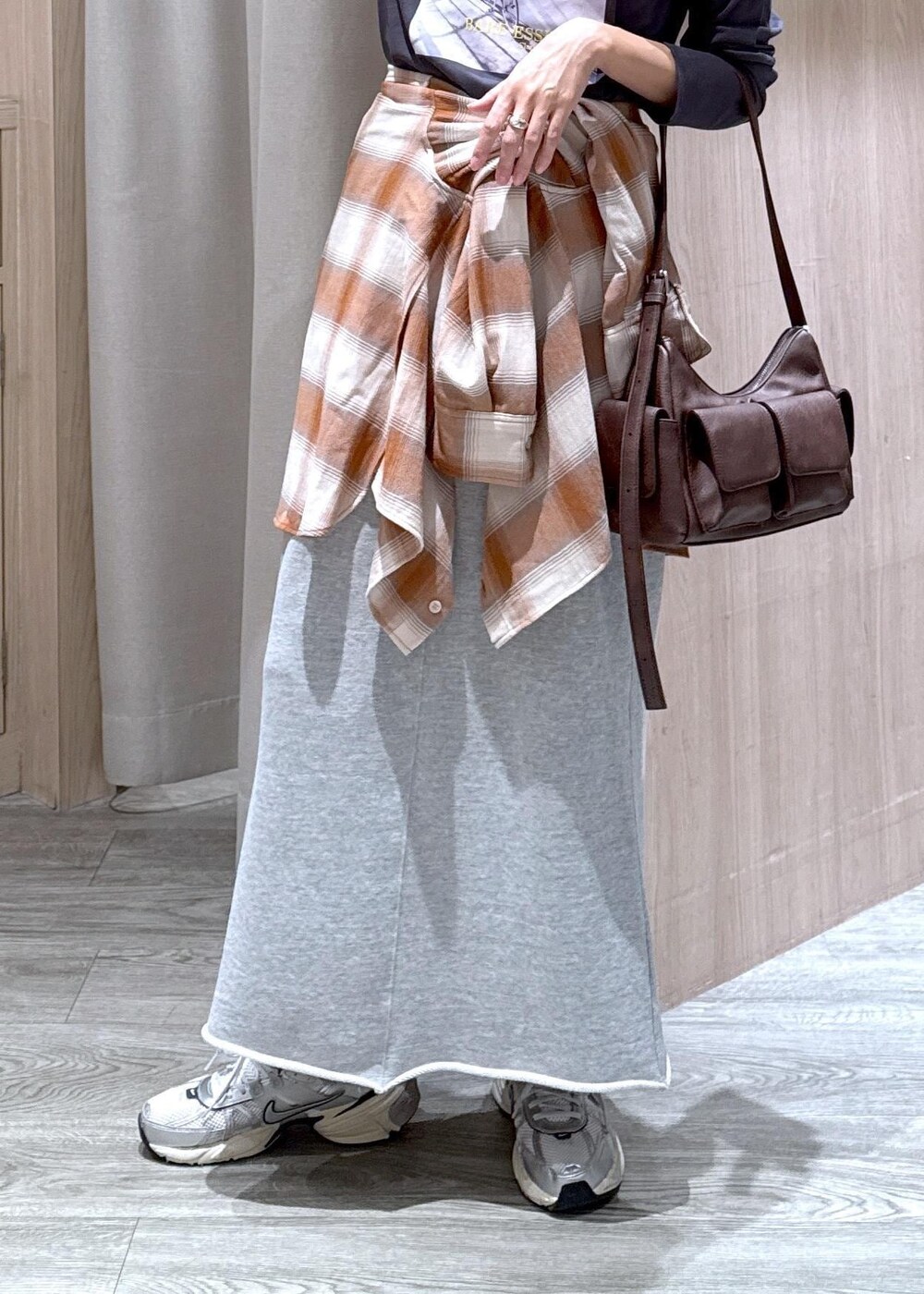グレー系のスカート、ベージュ系のシャツ/ブラウス、グレー系のTシャツ/カットソーを着用したレディースの秋コーディネートの6枚目の写真