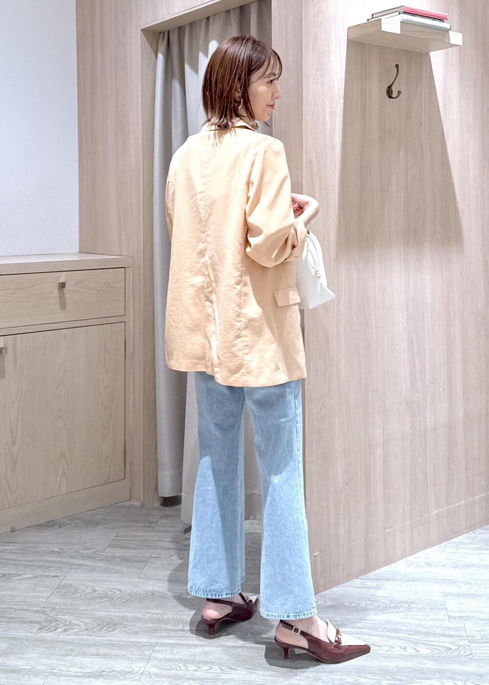 ブラウン系のパンプス、ホワイト系のTシャツ/カットソー、ブルー系のデニムパンツを着用したレディースの春コーディネートの3枚目の写真