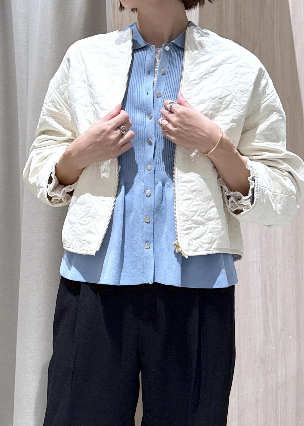 ブラック系のスラックス、ブラック系のショルダーバッグ、ブルー系のカーディガン/ボレロを着用したレディースの秋コーディネートの6枚目の写真