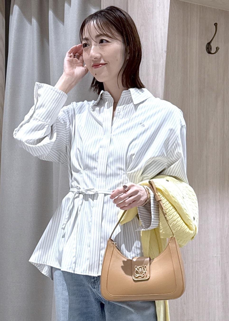 ブルー系のデニムパンツ、イエロー系のショルダーバッグ、ベージュ系のシャツ/ブラウスを着用したレディースの春コーディネートの6枚目の写真