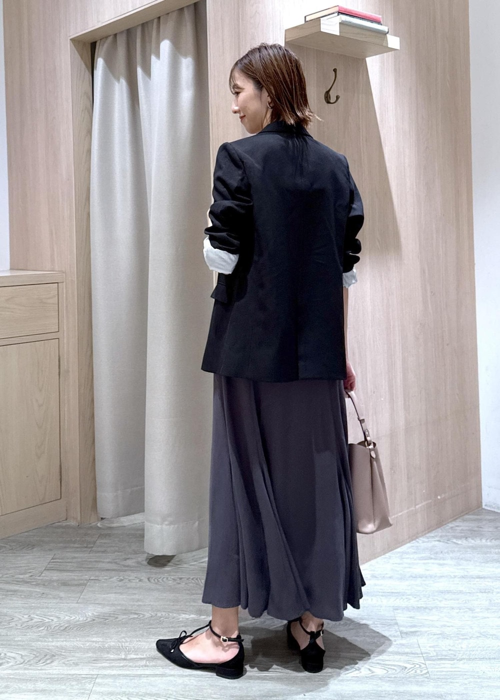ブラック系のパンプス、ブラック系のテーラードジャケット、ベージュ系のショルダーバッグを着用したレディースの秋コーディネートの3枚目の写真