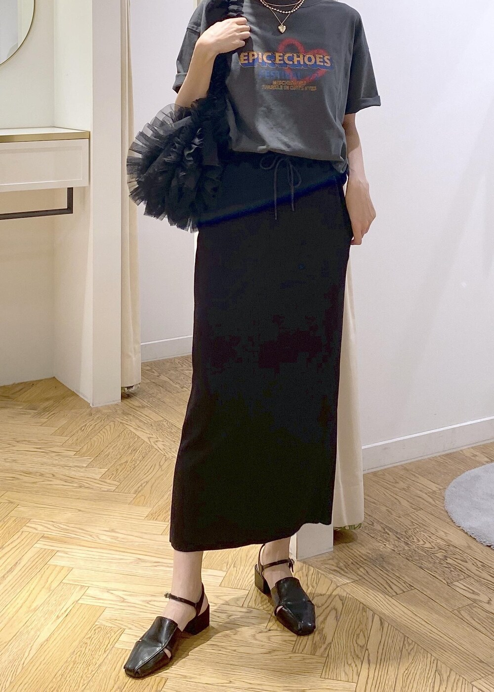 ブラック系のショルダーバッグ、ブラック系のスカート、グレー系のTシャツ/カットソーを着用したレディースの夏コーディネートの6枚目の写真