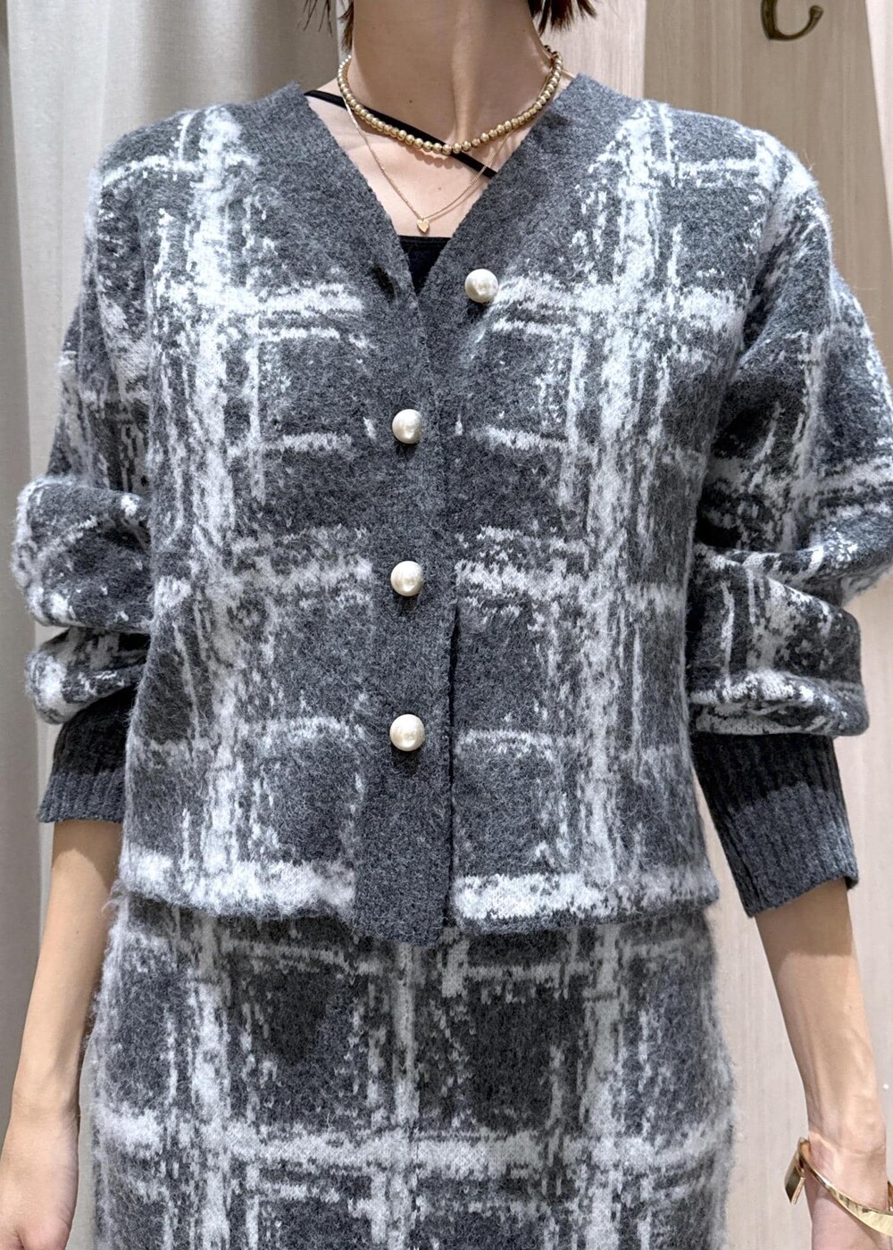 レッド系のボストンバッグ、ブラック系のダウンジャケット/コート、グレー系のスカートを着用したレディースの冬コーディネートの10枚目の写真