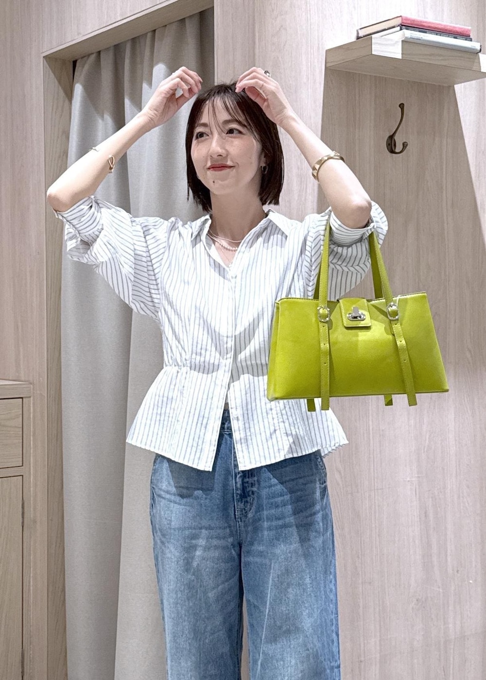 ブルー系のデニムパンツ、グリーン系のトートバッグ、ホワイト系のシャツ/ブラウスを着用したレディースの春コーディネートの5枚目の写真