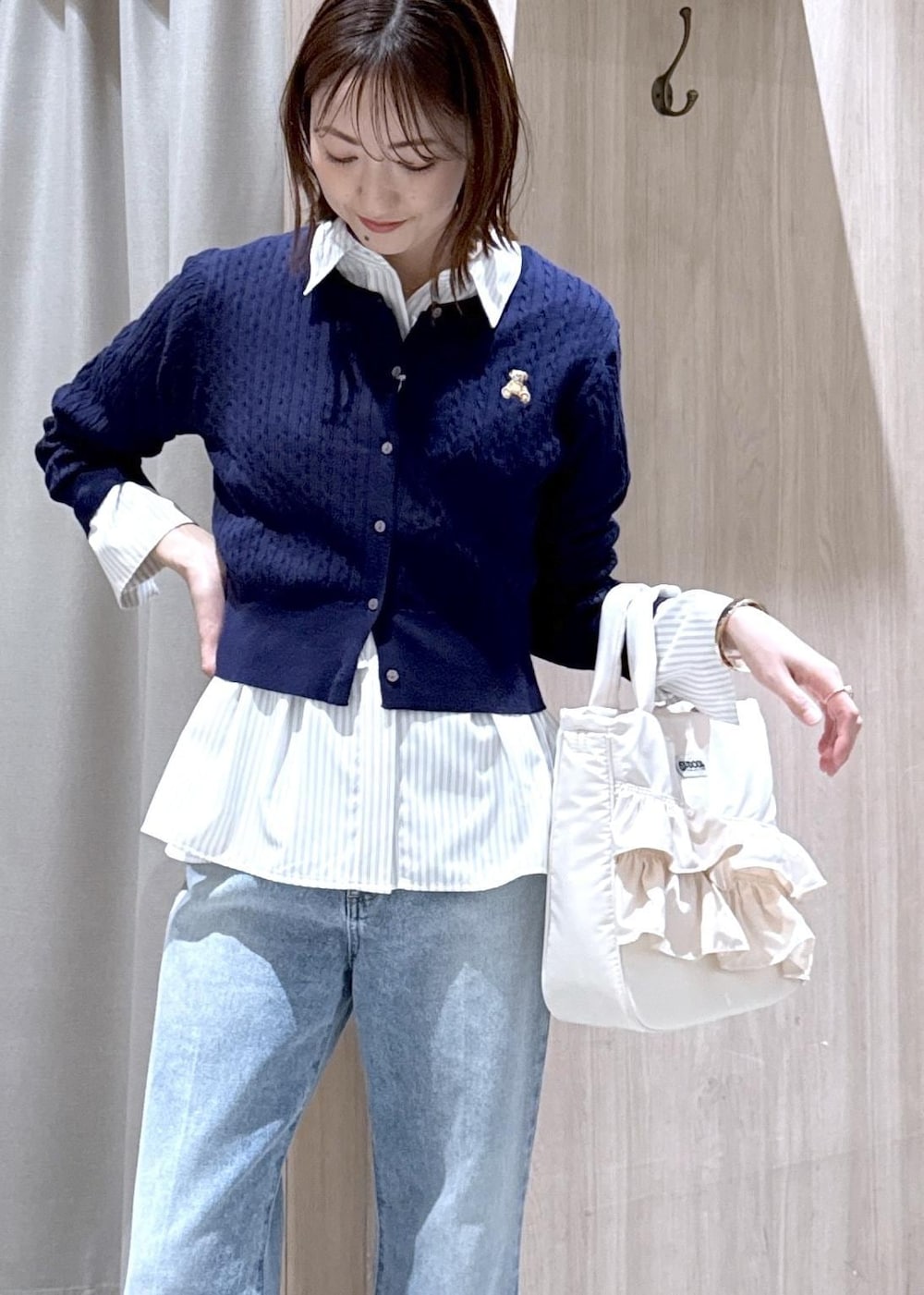 ブラック系のパンプス、ベージュ系のシャツ/ブラウス、ブルー系のカーディガン/ボレロを着用したレディースの春コーディネートの2枚目の写真