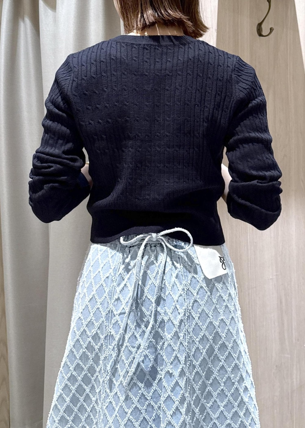 ホワイト系のショルダーバッグ、ブルー系のカーディガン/ボレロ、ブルー系のデニムスカートを着用したレディースの冬コーディネートの8枚目の写真