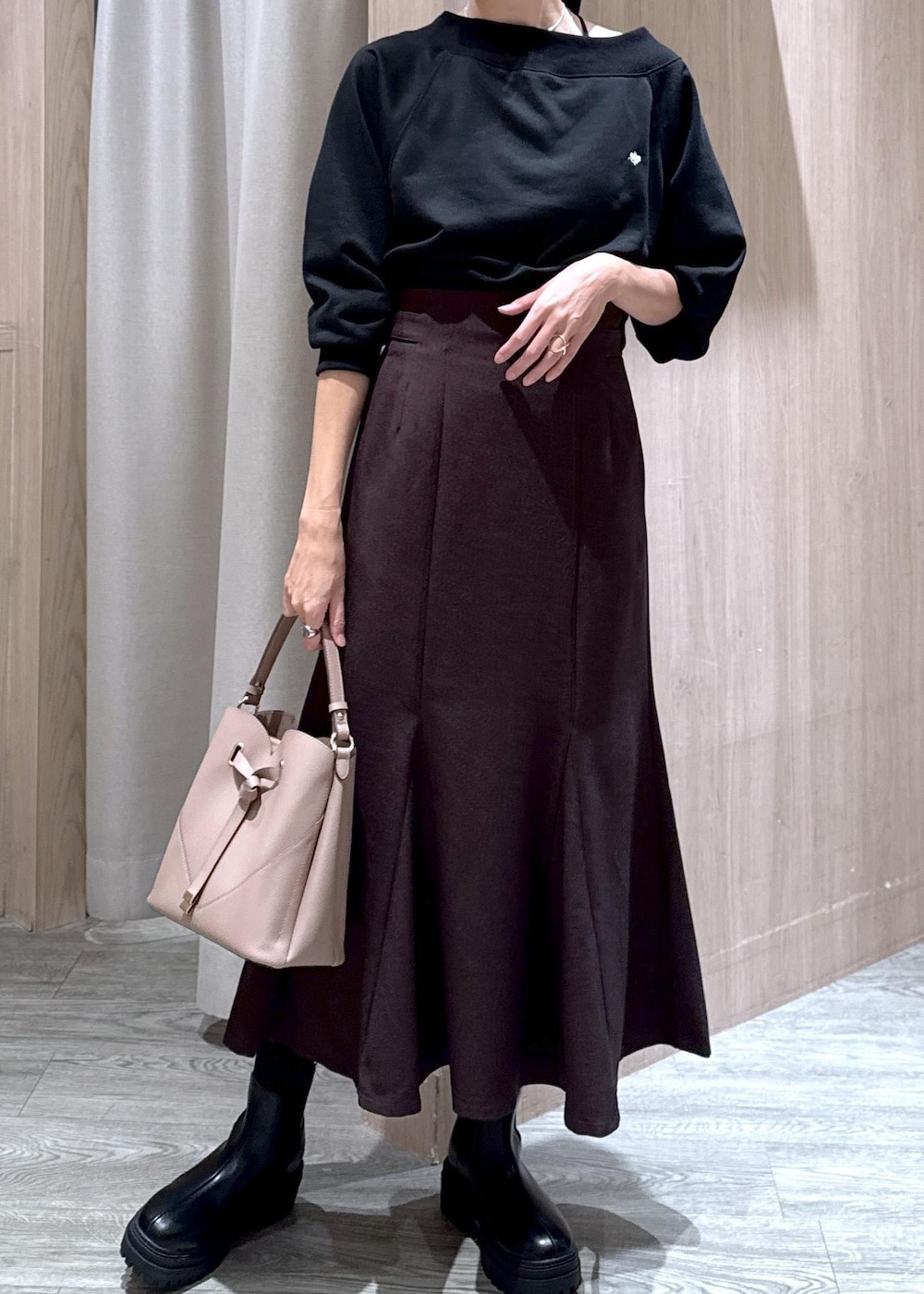 ブラック系のキャミソール、ブラウン系のスカート、ブラック系のブーツを着用したレディースの秋コーディネートの5枚目の写真