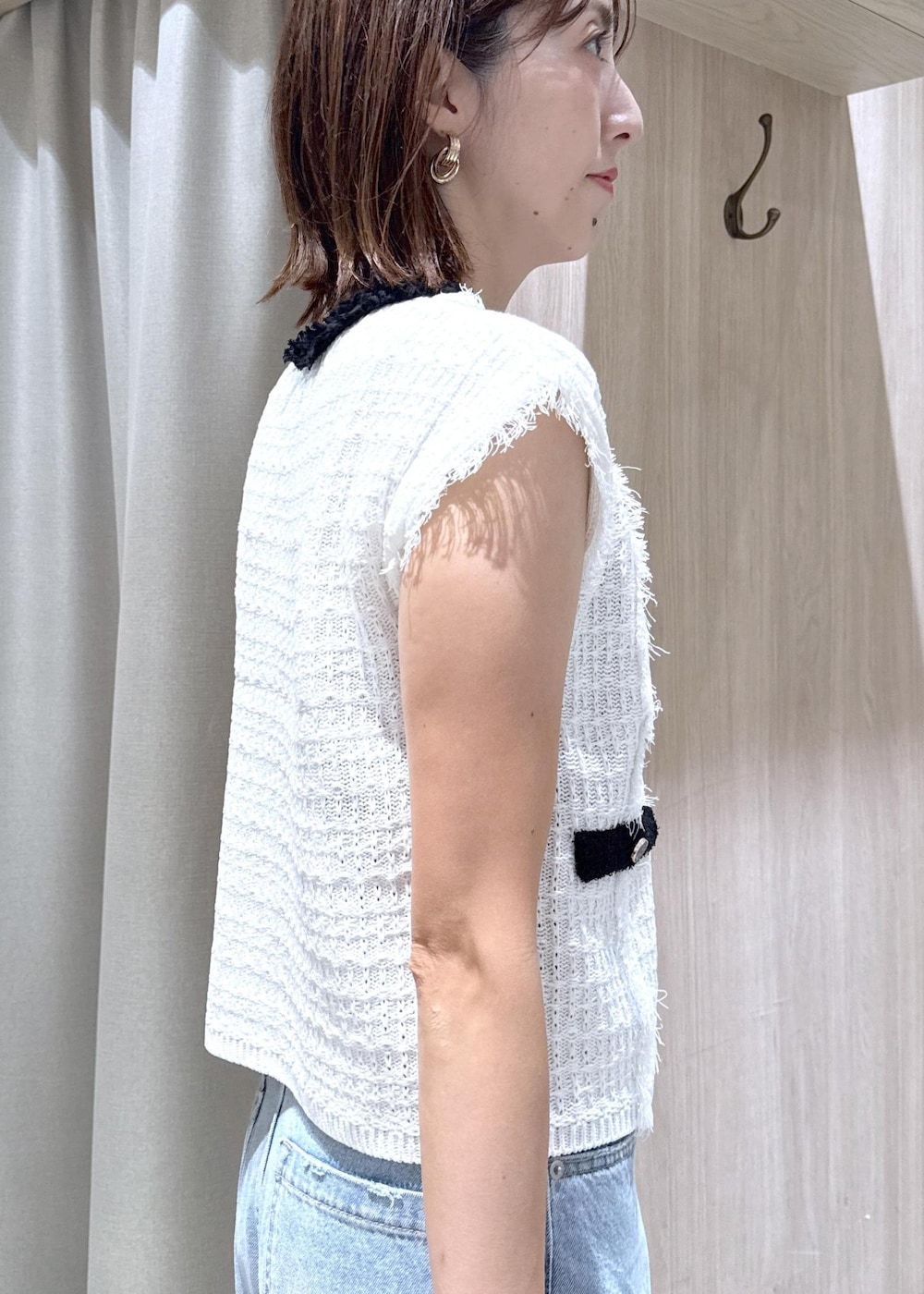 ブラック系のパンプス、ブルー系のデニムパンツ、ホワイト系のベストを着用したレディースの夏コーディネートの9枚目の写真