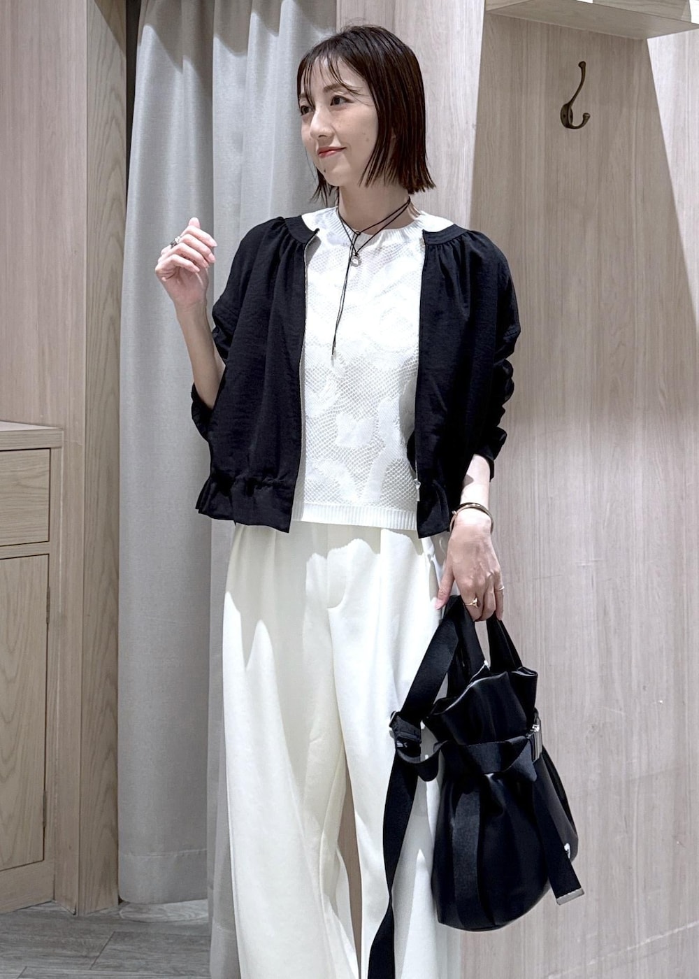 ブラック系のパンプス、ブラック系のトートバッグ、ブラック系のブルゾンを着用したレディースの春コーディネートの5枚目の写真