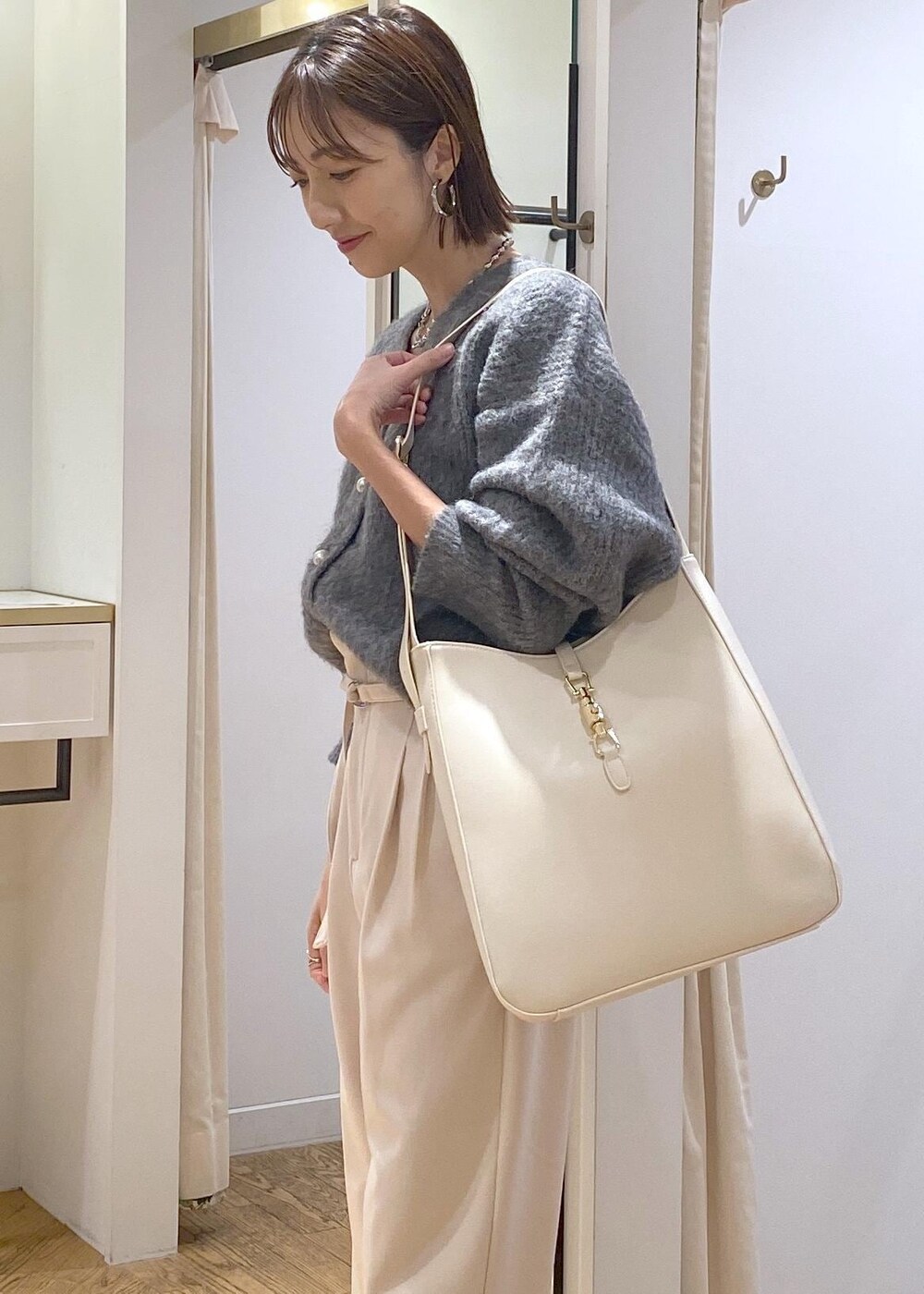 ホワイト系のトートバッグ、ブラック系のパンプス、ベージュ系のその他パンツを着用したレディースの冬コーディネートの7枚目の写真