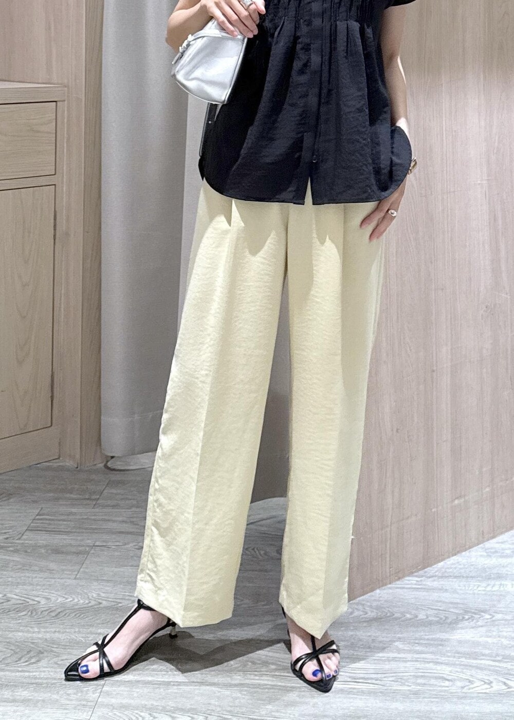 ブラック系のサンダル、イエロー系のスラックス、ブラック系のシャツ/ブラウスを着用したレディースの夏コーディネートの5枚目の写真