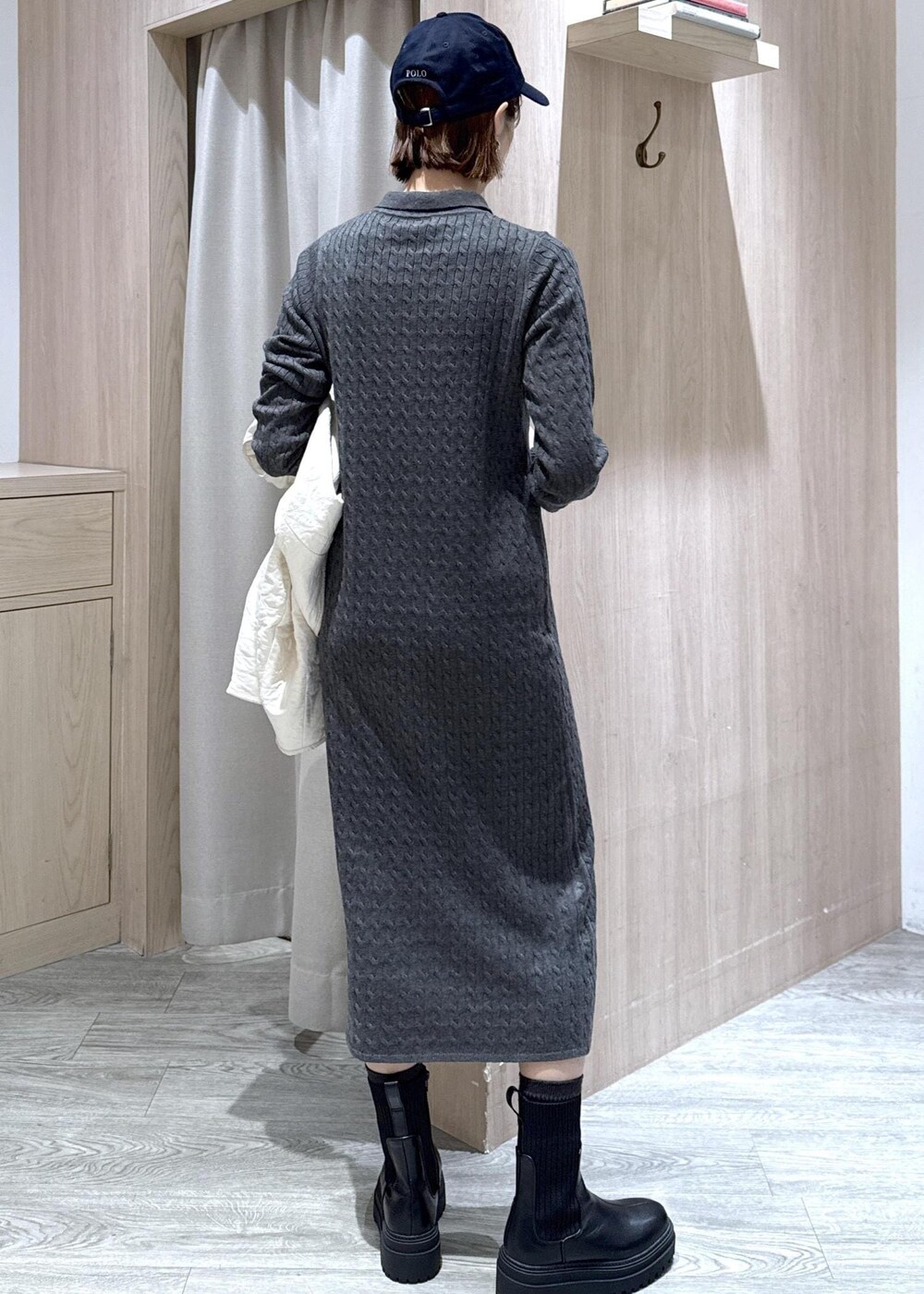 ブラック系のショルダーバッグ、ブラック系のブーツ、ホワイト系のブルゾンを着用したレディースの秋コーディネートの9枚目の写真