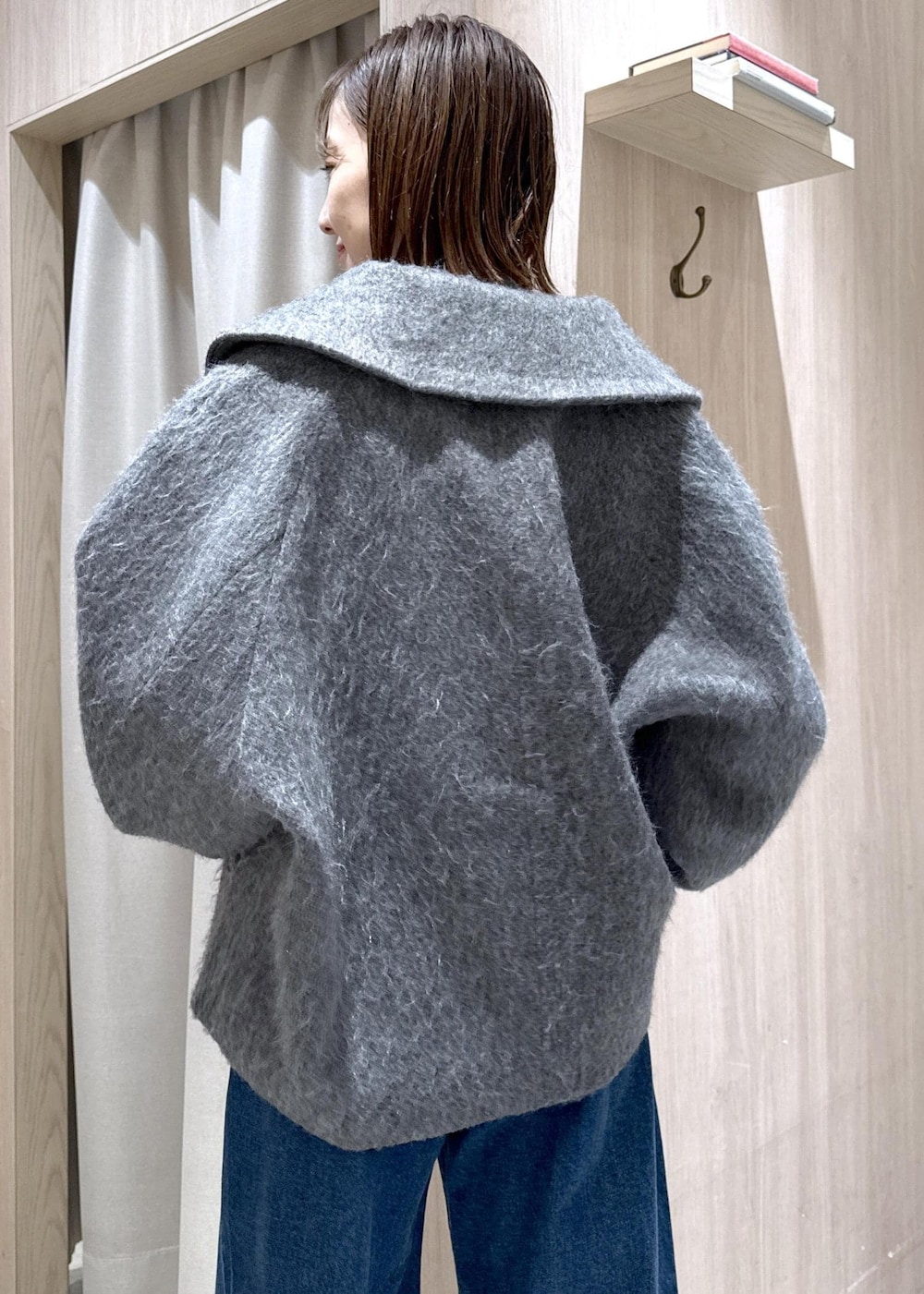 ブラック系のショルダーバッグ、ブルー系のデニムパンツ、グレー系のブルゾンを着用したレディースの冬コーディネートの5枚目の写真