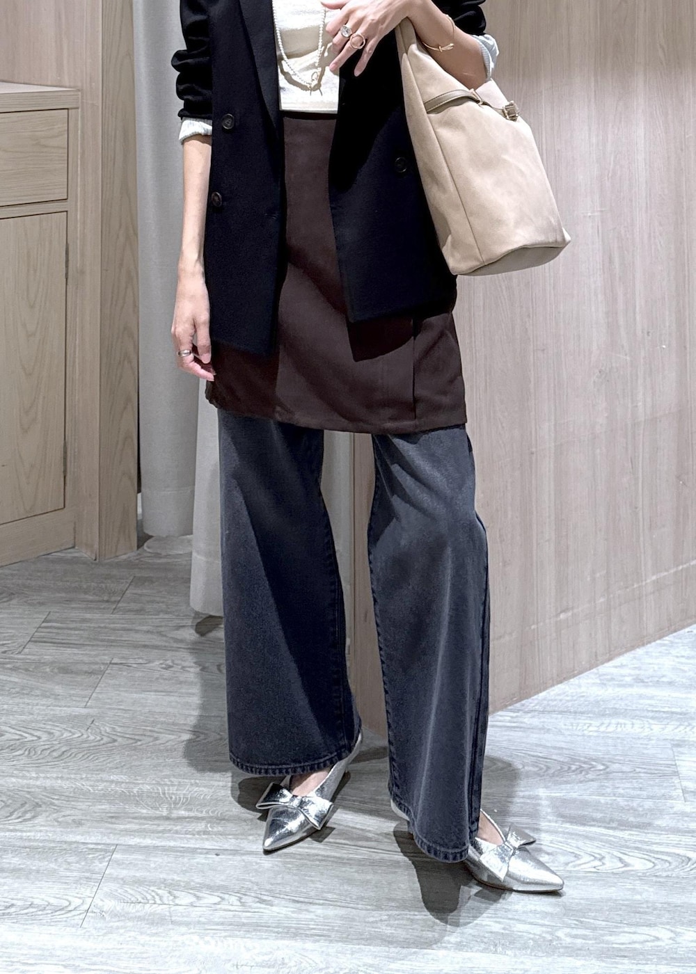 シルバー系のパンプス、ベージュ系のショルダーバッグ、ブラック系のテーラードジャケットを着用したレディースの秋コーディネートの6枚目の写真