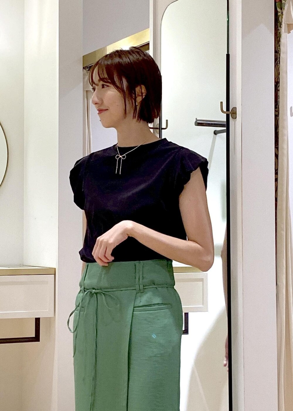 ブラック系のショルダーバッグ、ブラック系のサンダル、ホワイト系のカーディガン/ボレロを着用したレディースの夏コーディネートの4枚目の写真