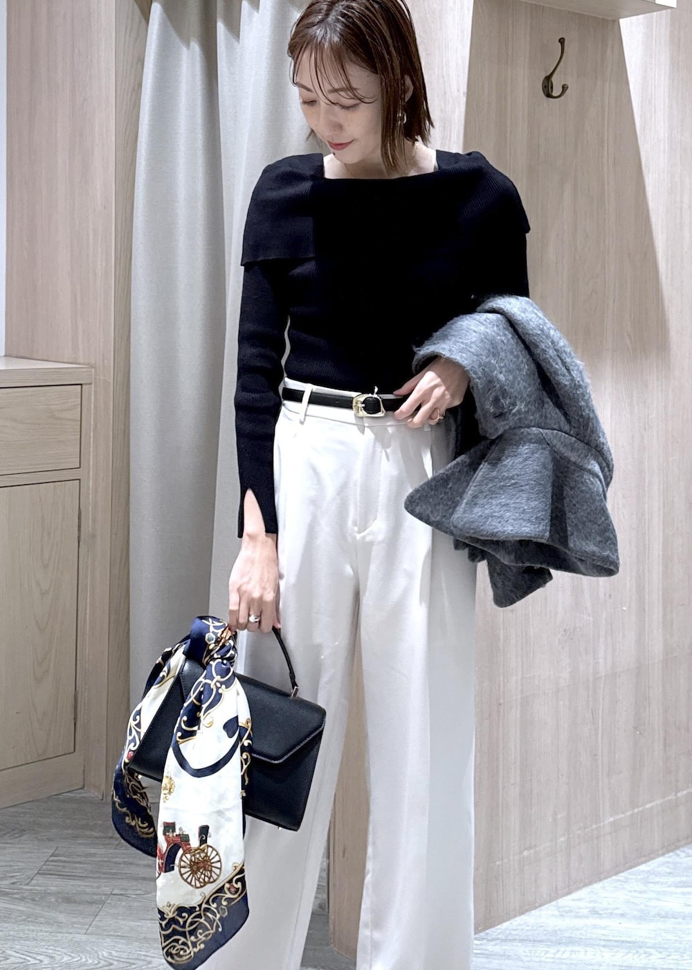 ブラック系のニット/セーター、グレー系のブルゾン、ブラック系のハンドバッグを着用したレディースの冬コーディネートの4枚目の写真