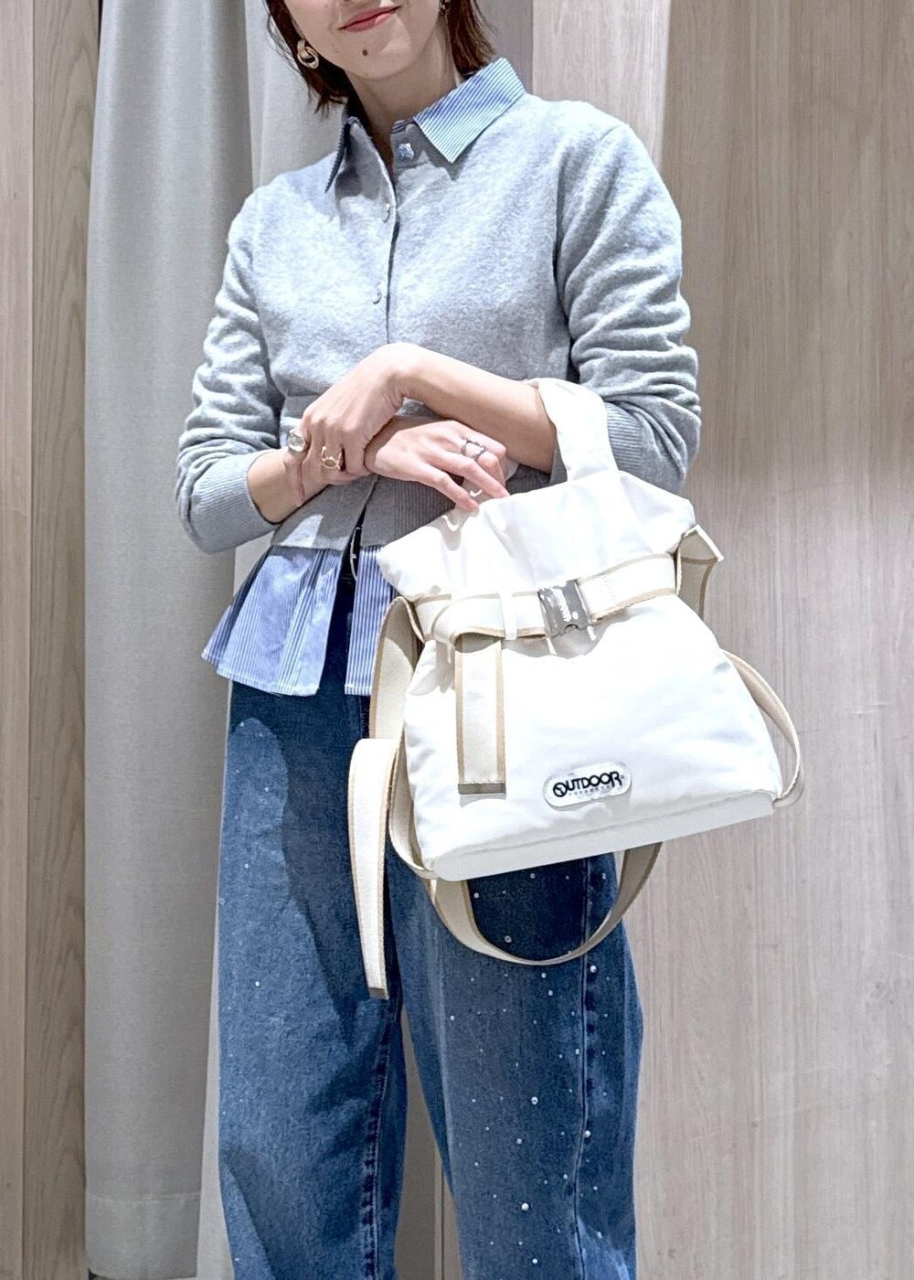 ブルー系のデニムパンツ、グレー系のカーディガン/ボレロ、ホワイト系のトートバッグを着用したレディースの冬コーディネートの7枚目の写真