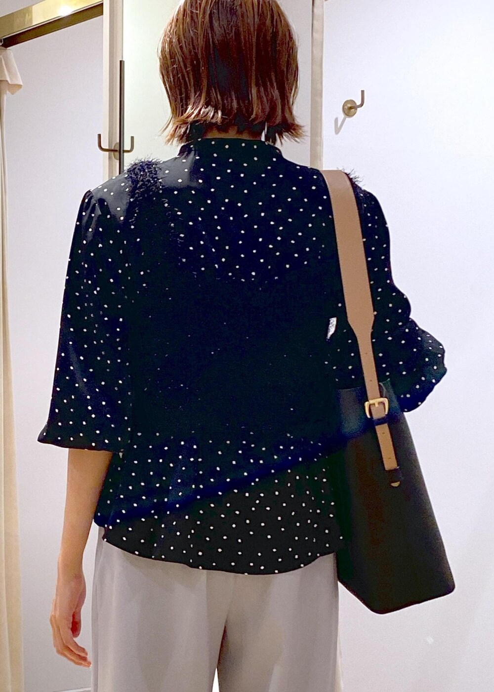 ブラック系のショルダーバッグ、ブラック系のバレエシューズ、ブラック系のキャミソールを着用したレディースの秋コーディネートの6枚目の写真