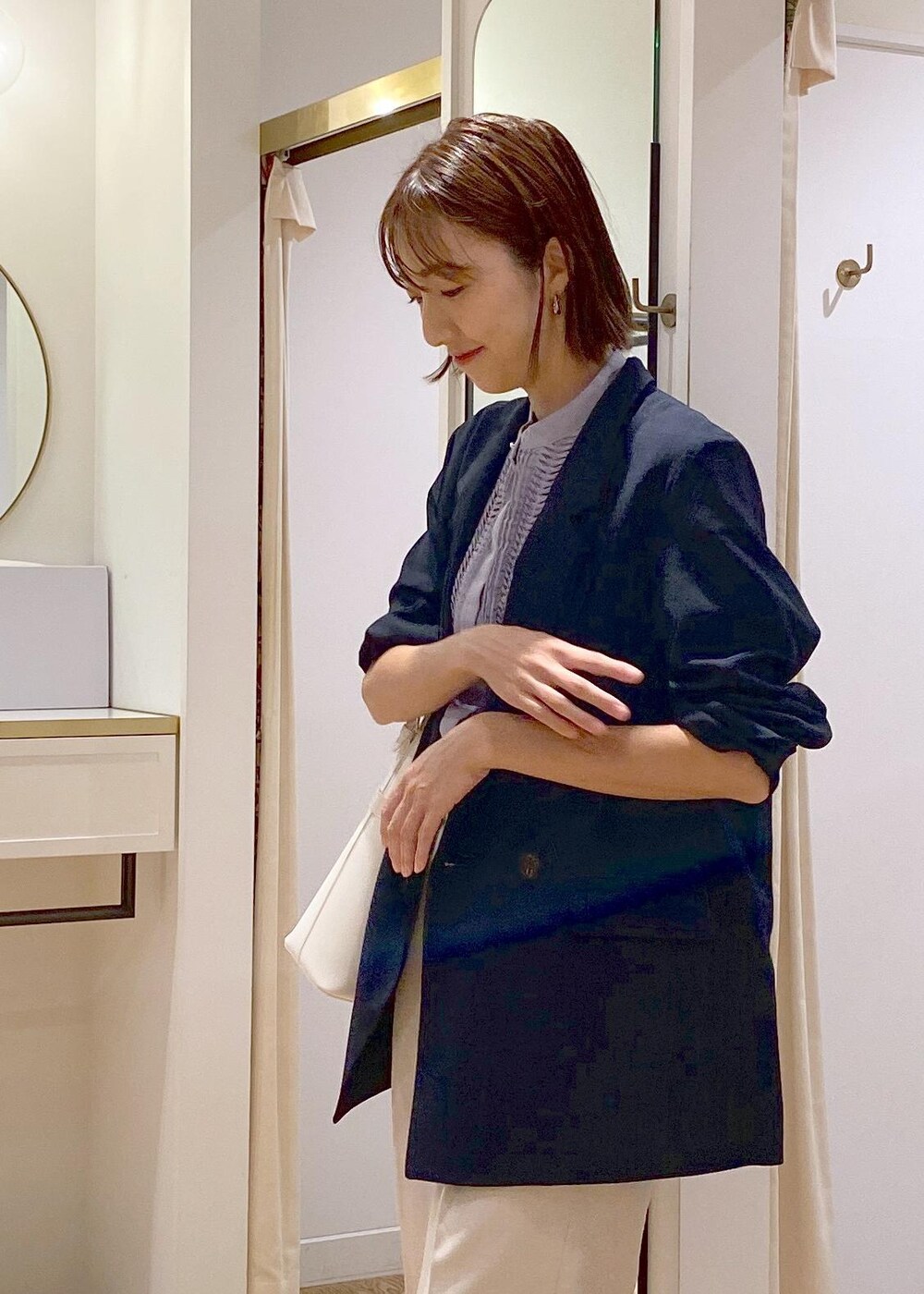 ブルー系のテーラードジャケット、ブルー系のシャツ/ブラウス、ホワイト系のスラックスを着用したレディースの夏コーディネートの9枚目の写真