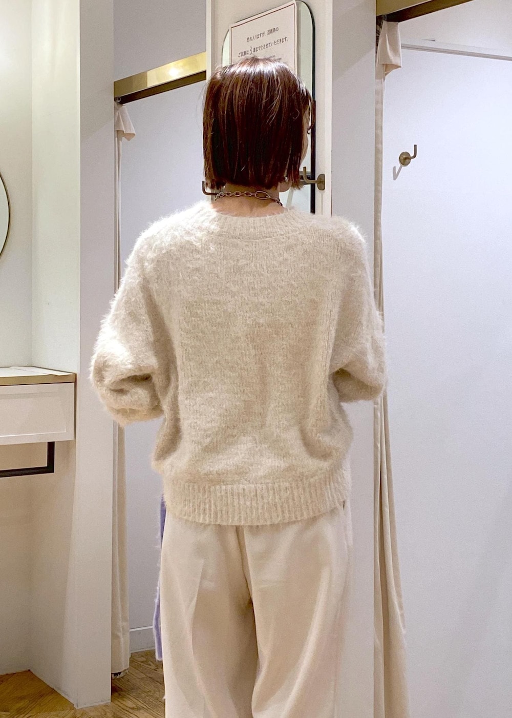 ベージュ系のニット/セーター、ホワイト系のスラックス、ホワイト系のショルダーバッグを着用したレディースの冬コーディネートの8枚目の写真