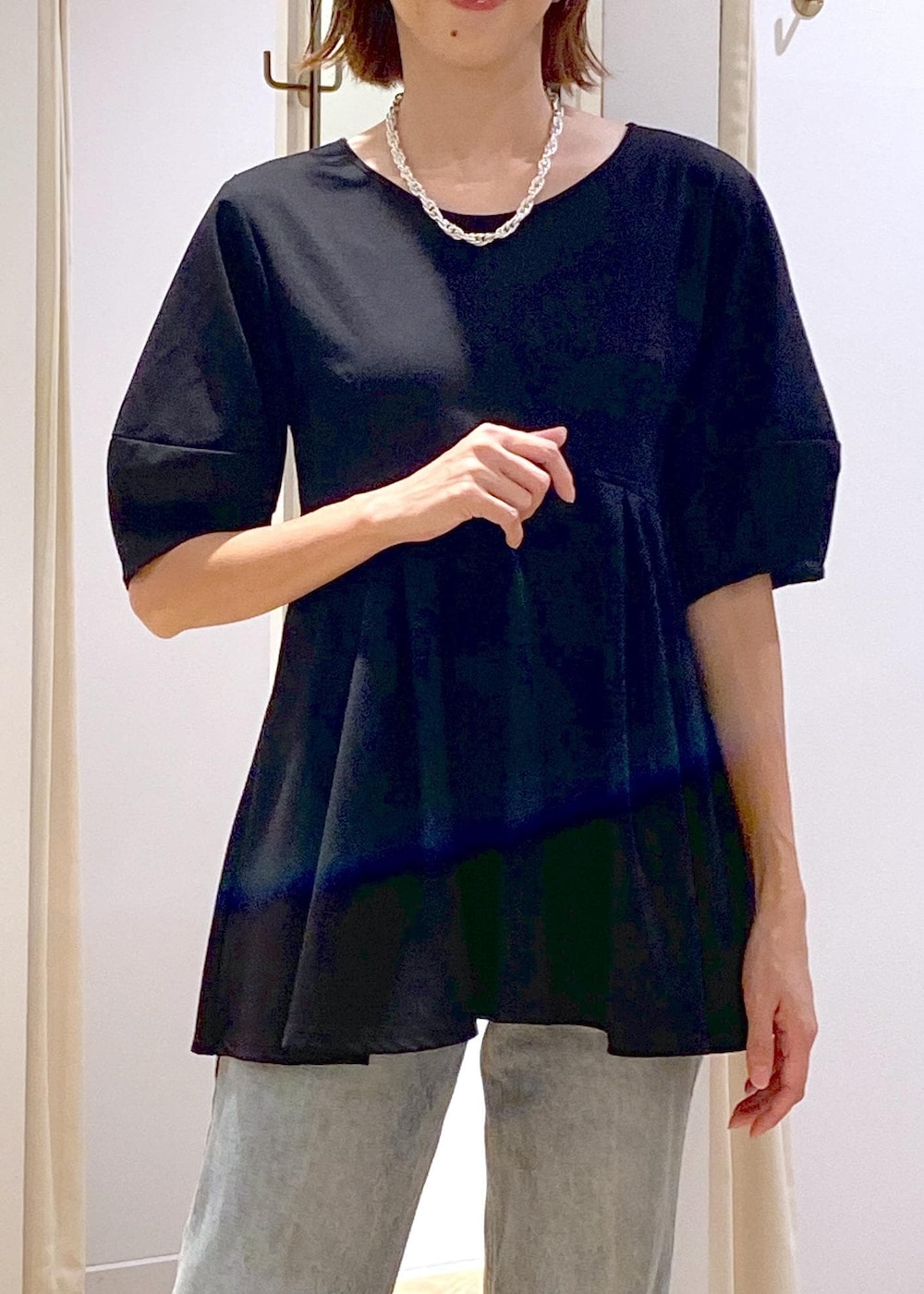 ブラック系のブーツ、ブラック系のTシャツ/カットソー、ブルー系のデニムパンツを着用したレディースの秋コーディネートの9枚目の写真