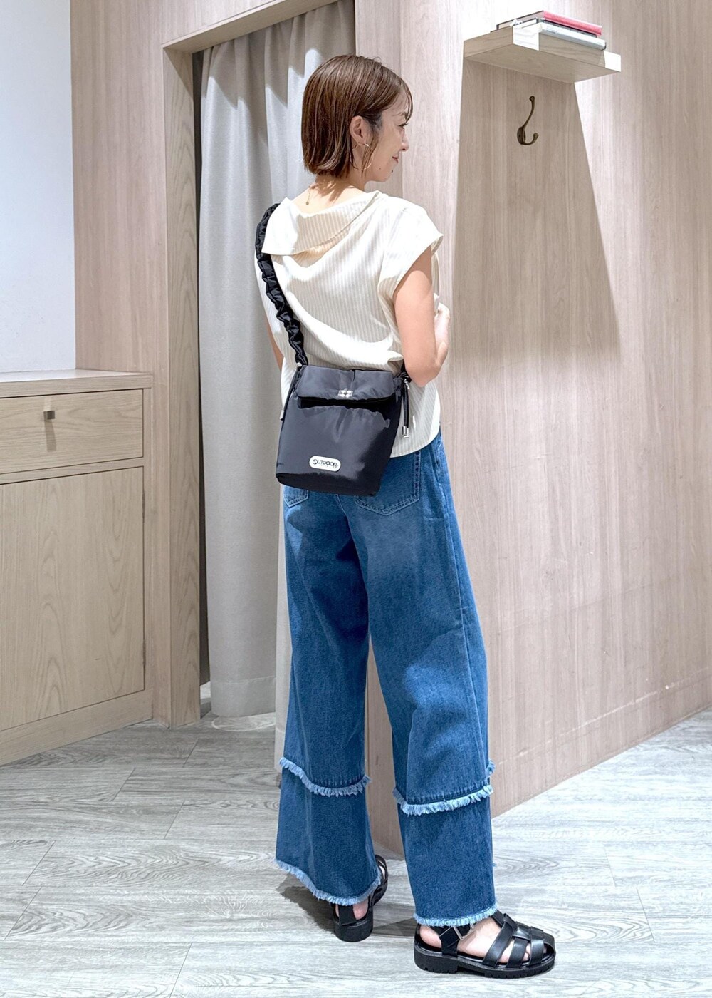 ベージュ系のキャミソール、ベージュ系のシャツ/ブラウス、ブルー系のデニムパンツを着用したレディースの夏コーディネートの4枚目の写真