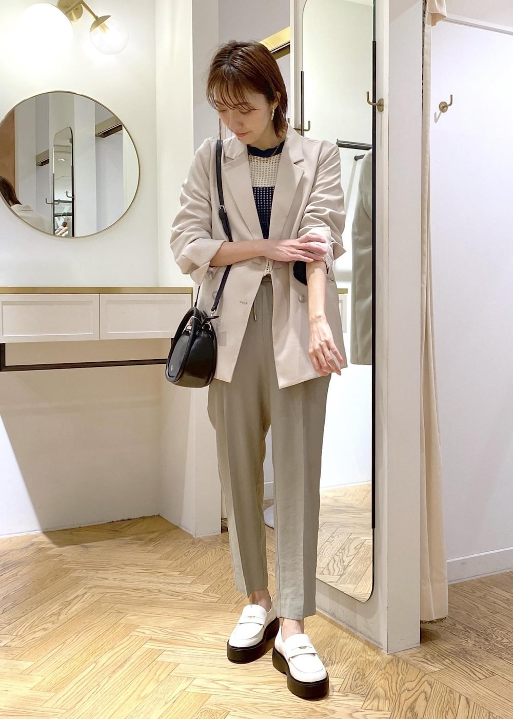 ホワイト系のローファー、ブラック系のショルダーバッグ、ブルー系のニット/セーターを着用したレディースの春コーディネートの4枚目の写真