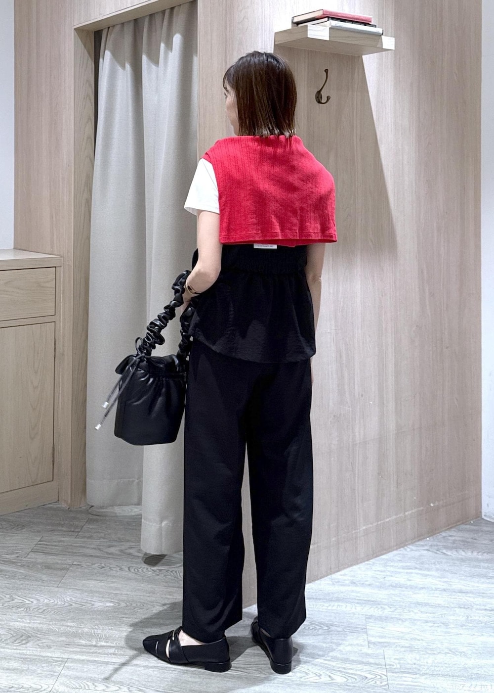 ブラック系のショルダーバッグ、ブラック系のパンプス、レッド系のカーディガン/ボレロを着用したレディースの春コーディネートの5枚目の写真