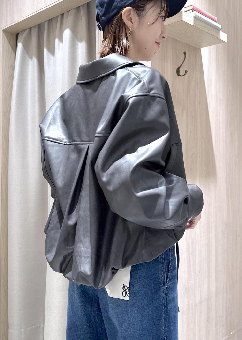 ホワイト系のトートバッグ、ブラック系のブルゾン、ホワイト系のTシャツ/カットソーを着用したレディースの冬コーディネートの7枚目の写真