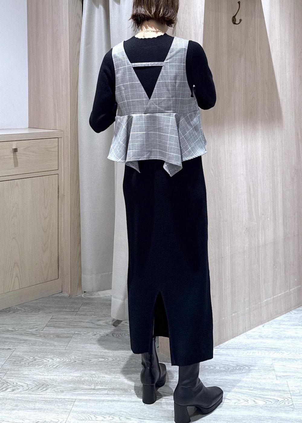 ブルー系のハンドバッグ、ホワイト系のノーカラージャケット、ブラック系のブーツを着用したレディースの秋コーディネートの4枚目の写真