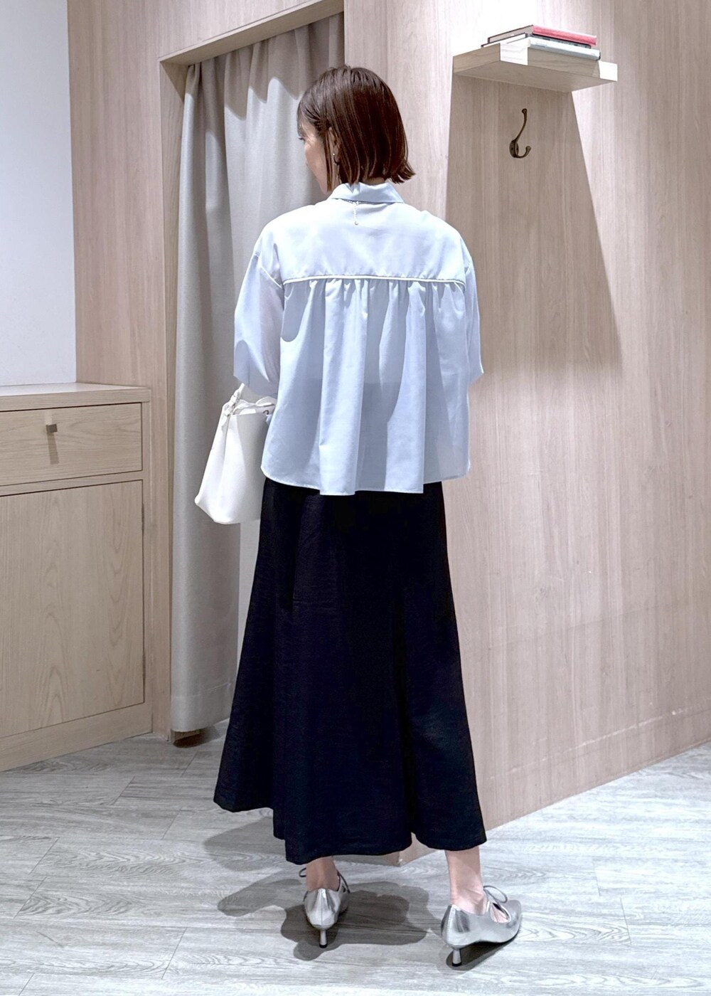 ホワイト系のショルダーバッグ、シルバー系のパンプス、ブラック系のスカートを着用したレディースの春コーディネートの4枚目の写真