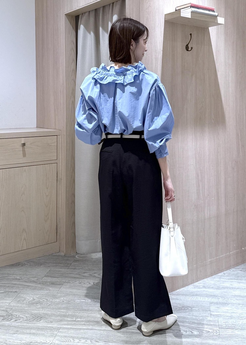 ホワイト系のショルダーバッグ、ブルー系のシャツ/ブラウス、ホワイト系のパンプスを着用したレディースの春コーディネートの2枚目の写真