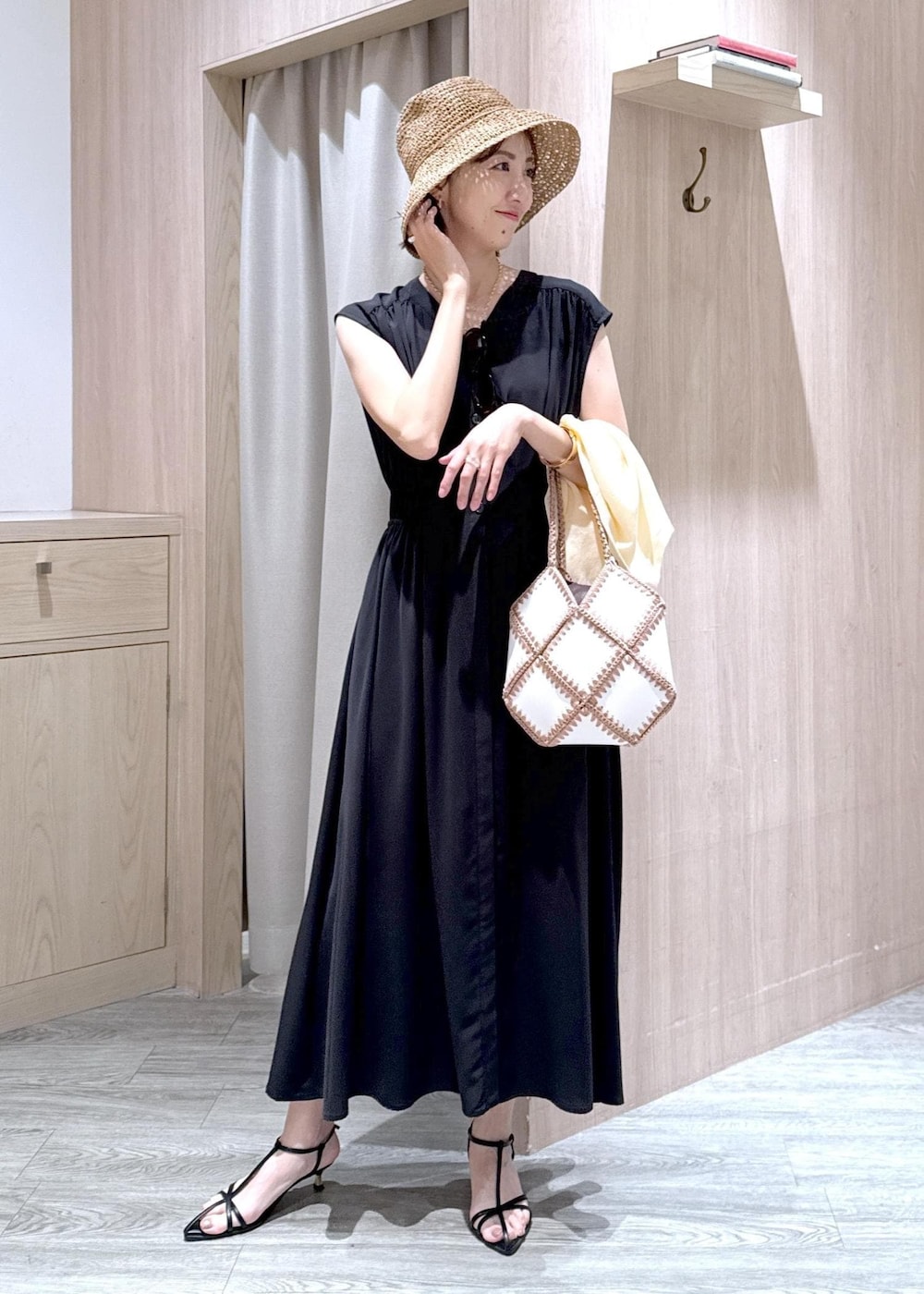 ブラック系のサンダル、ホワイト系のハンドバッグ、ホワイト系のカーディガン/ボレロを着用したレディースの春コーディネートの2枚目の写真