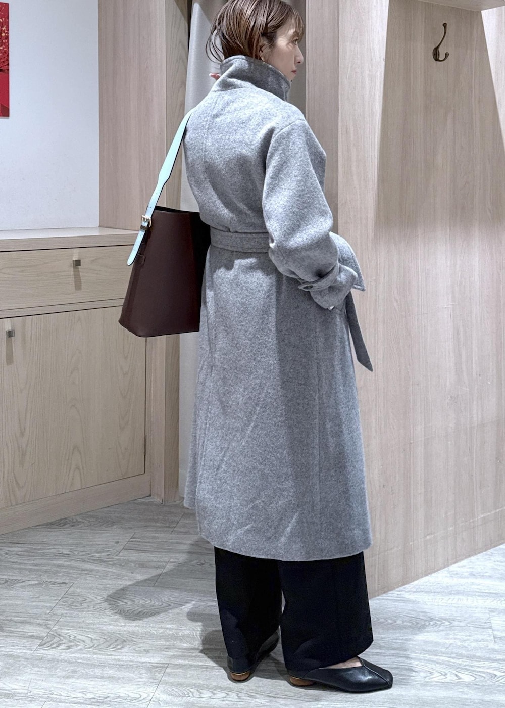 ホワイト系のニット/セーター、グレー系のその他アウター、ブラック系のスラックスを着用したレディースの冬コーディネートの4枚目の写真