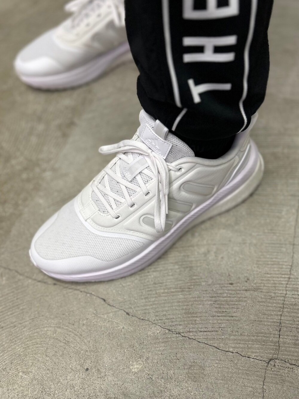 ホワイト系のTシャツ/カットソー、ブラック系のその他パンツ、ホワイト系のシューズを着用したメンズの秋コーディネートの3枚目の写真