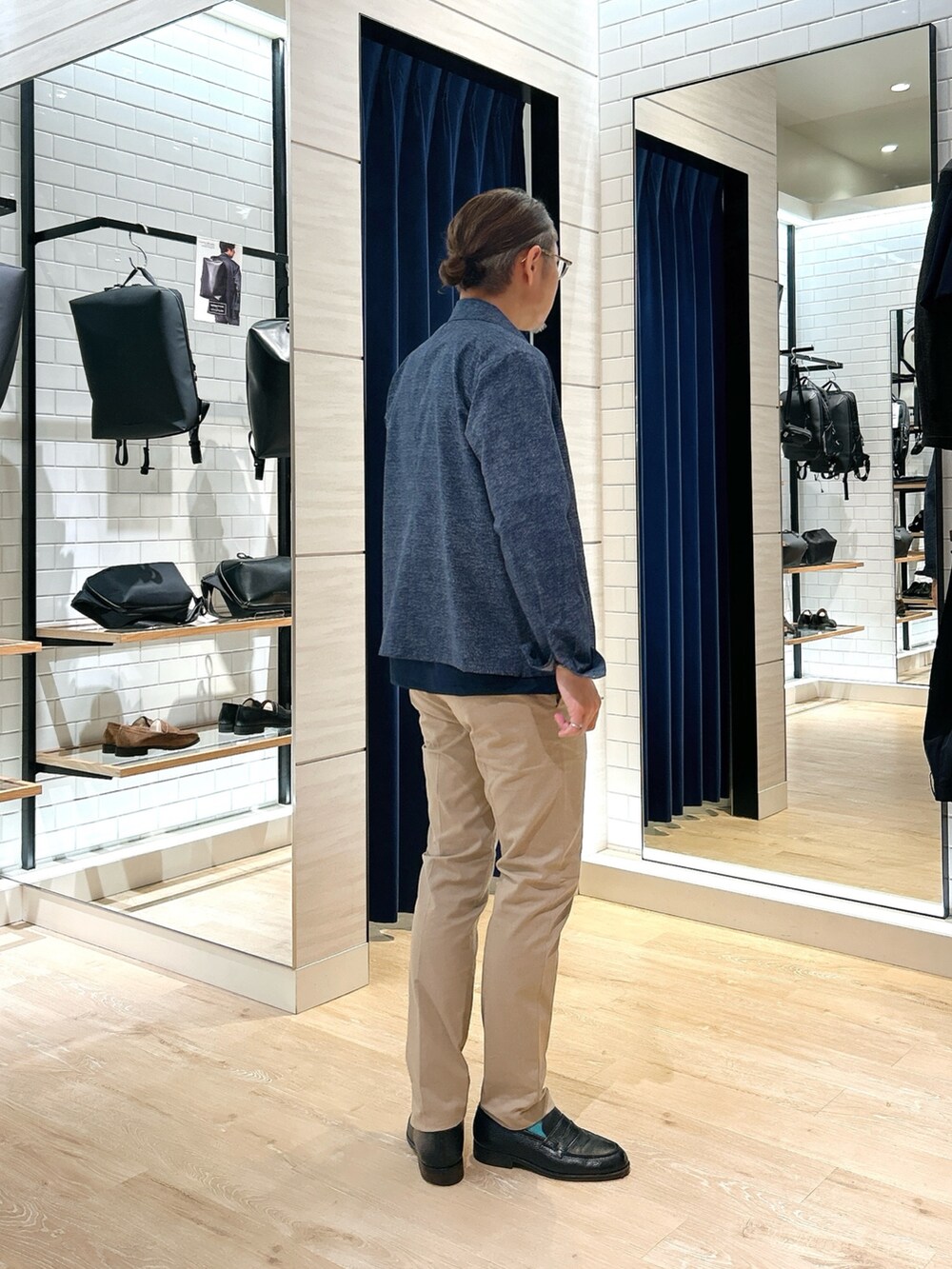 ブルー系のブルゾン、ブルー系のTシャツ/カットソー、ベージュ系のチノパンツを着用したメンズの春コーディネートの5枚目の写真