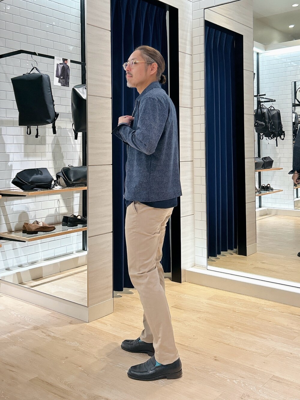 ブルー系のブルゾン、ブルー系のTシャツ/カットソー、ベージュ系のチノパンツを着用したメンズの春コーディネートの4枚目の写真