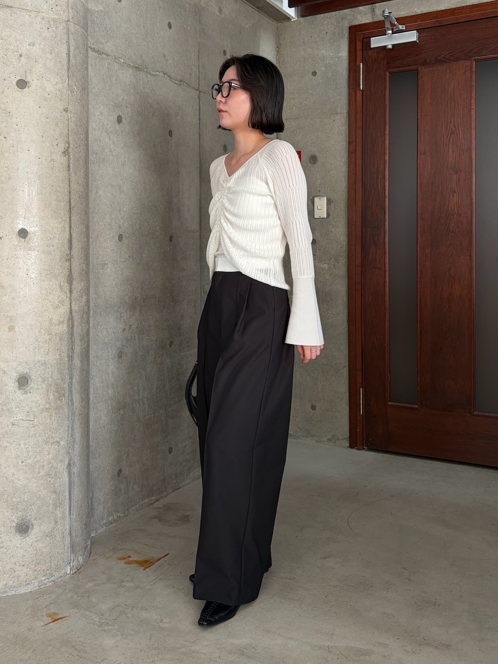 ホワイト系のニット/セーター、ホワイト系のその他パンツ、ブラック系のショルダーバッグを着用したレディースの春コーディネートの4枚目の写真