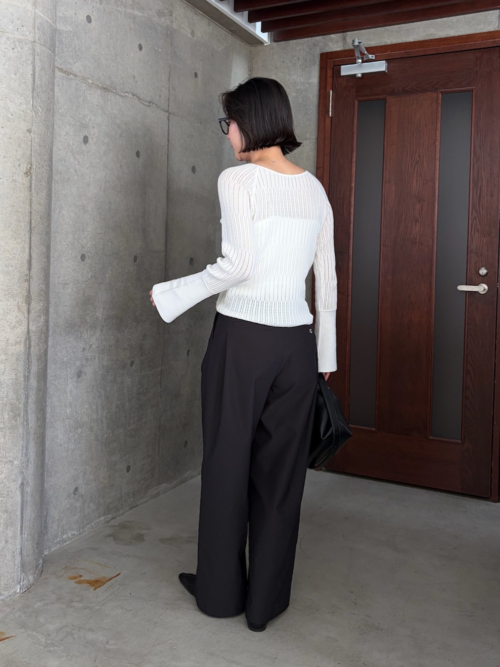 ホワイト系のニット/セーター、ホワイト系のその他パンツ、ブラック系のショルダーバッグを着用したレディースの春コーディネートの5枚目の写真