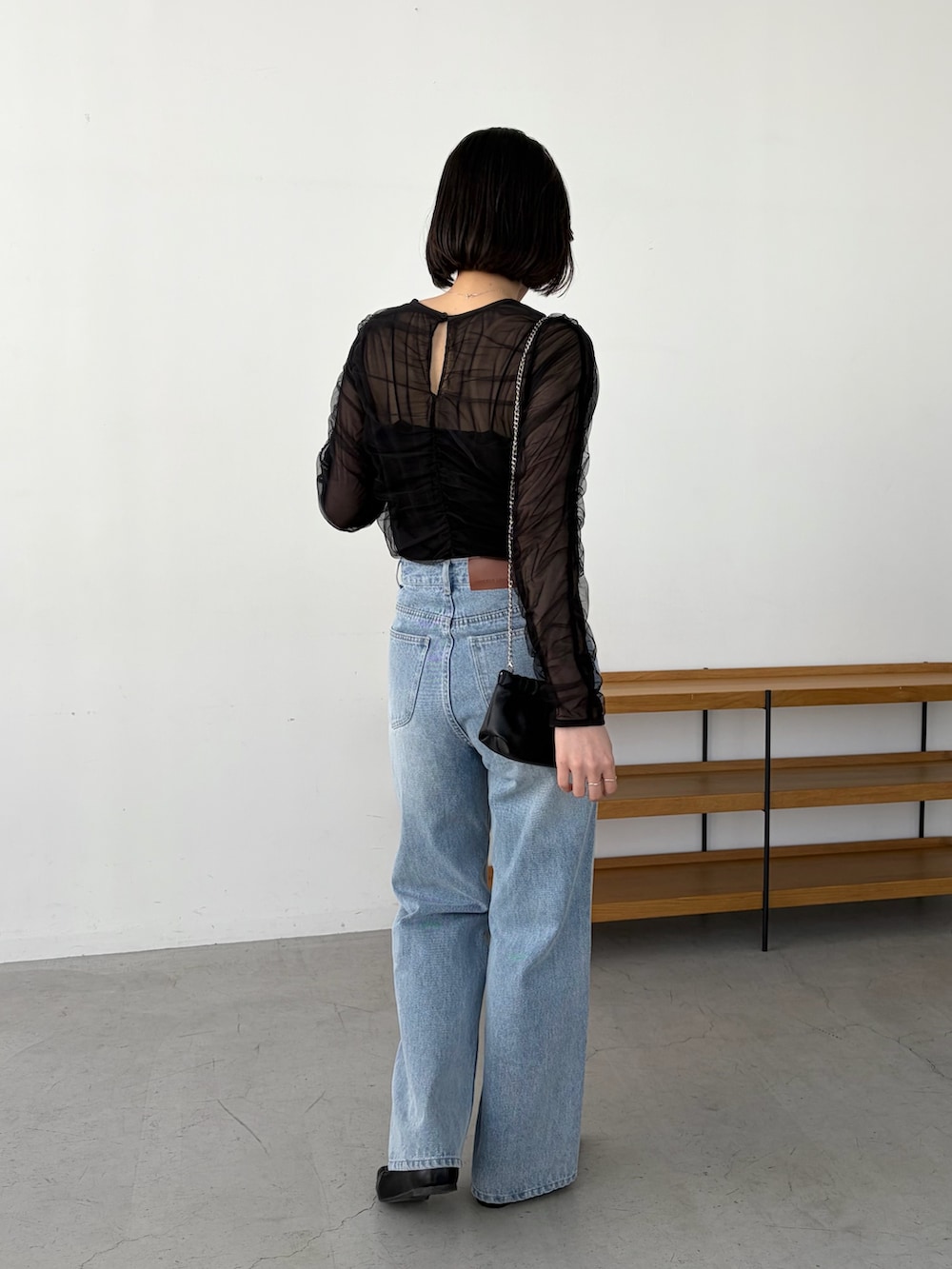 ブルー系のデニムパンツ、ブラック系のシャツ/ブラウス、ブラック系のショルダーバッグを着用したレディースの春コーディネートの4枚目の写真