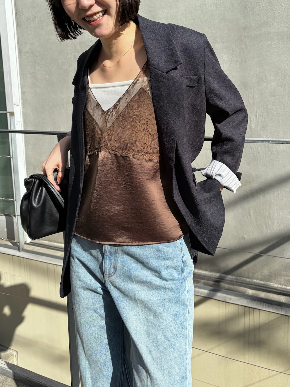 ブラウン系のシャツ/ブラウス、ブラック系のテーラードジャケット、ブラック系のショルダーバッグを着用したレディースの冬コーディネートの3枚目の写真